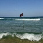 דגל שחור מסמן את מיקומו של זרם פריצה הסוחף לעומק הים – חוף דדו – חיפה (צילום: ירון כרמי)
